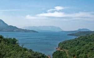Scenic view of Mulshi Lake surrounded by lush green hills and calm water in Lonavala